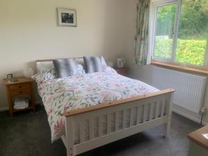 a bedroom with a bed with a floral bedspread and a window at Wingmore in Salisbury