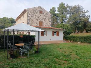 un tavolo e sedie sotto una tenda in un cortile di Casa Eufemia a Marasi