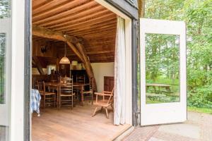 an open door to a patio with a table and chairs at Prachtig vrijstaand familiehuis op groot perceel in Scherpenzeel