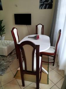 a dining room table with two chairs and a tv at Johari Shared Studio Westlands in Nairobi