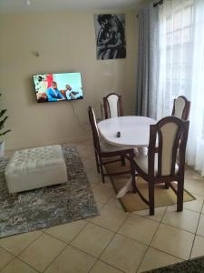 een woonkamer met een witte tafel en stoelen bij Johari Shared Studio Westlands in Nairobi