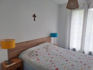 a bedroom with a bed with a cross on the wall at Bel appartement indépendant et lumineux in Bartrés