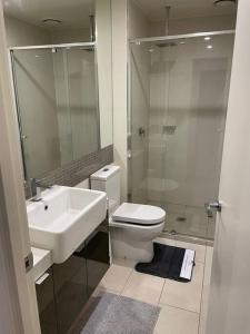 een badkamer met een wastafel, een toilet en een douche bij MEL 1BED Entire Apt next 2 Crown For 3PP in Melbourne