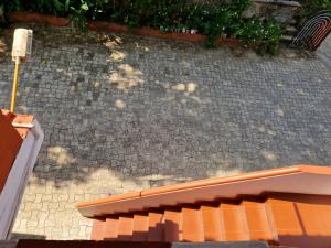 an orange bench sitting on a brick sidewalk at Gladsvilla in Mangalore