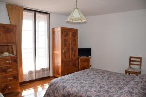 a bedroom with a bed and a dresser and a tv at Appartamento La Fenice Rango in Balbido-rango