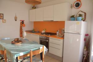 a kitchen with a white refrigerator and a table at Appartamento La Fenice Rango in Balbido-rango