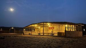 een gebouw met lichten aan in de woestijn 's nachts bij Sand Delight Camp in Al Wāşil