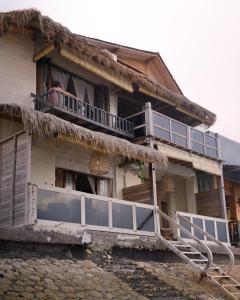 an old house with a balcony and a porch at La Beach Penida in Nusa Penida