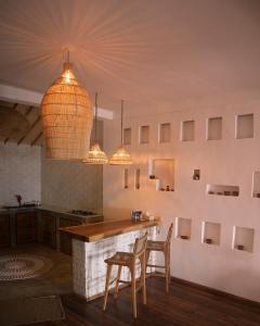 a kitchen with two chairs and a counter in a room at La Beach Penida in Nusa Penida