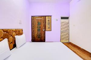 - une chambre avec un grand lit et une porte en bois dans l'établissement Super OYO New Paradise Guest House, 