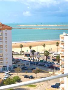 - une vue sur la plage et l'océan depuis un bâtiment dans l'établissement Frente al mar, preciosas vistas, piscinas , valdelagrana, à El Puerto de Santa María
