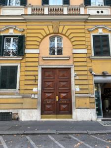 een gebouw met een houten deur en twee ramen bij Vatican Tiny House in Rome