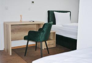 ein Schlafzimmer mit einem Schreibtisch und einem Stuhl neben einem Bett in der Unterkunft Hotel Divanhana in Brčko