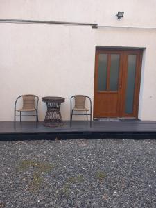 two chairs and a table in front of a building at Happy Guests Residence in Sibiu