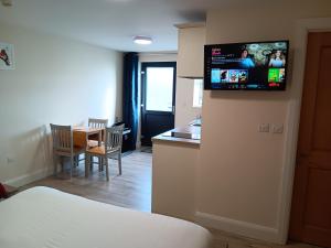 um quarto com uma cozinha com uma televisão na parede em Matty's Pub - Apartment's em Carlow