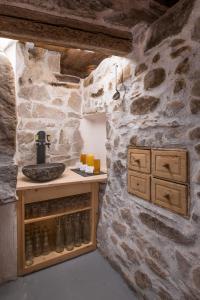 a bathroom with a stone wall and a sink at Breitachhus in Riezlern