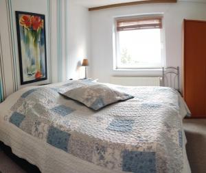 een slaapkamer met een bed met een quilt bij Wohnung am Wanderweg zum Königsstuhl unter Reet in Lohme