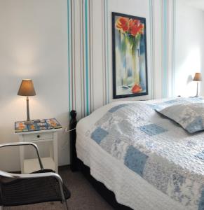 1 dormitorio con 1 cama y un jarrón de flores en Wohnung am Wanderweg zum Königsstuhl unter Reet, en Lohme