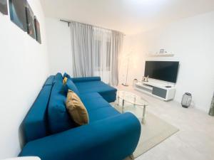 um sofá azul numa sala de estar com uma televisão em 1-3 Pers. 0,9 km zum Zentrum - moderne Wohnung in Remscheid em Remscheid