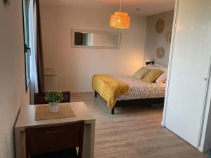 Un dormitorio con una cama con una manta amarilla. en Appart'Hotel - Gare TGV - Courtine - Confluence - 202 en Aviñón
