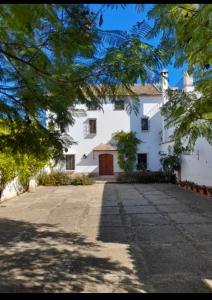 a large white house with a large driveway at La Capellania de Alvear in Montilla