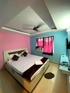 a bedroom with a bed with pink and blue walls at Goroomgo Chandrabindu Near Sea Beach Puri in Puri