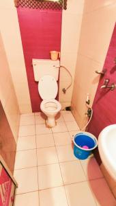 a bathroom with a toilet and a sink and a bucket at Goroomgo Chandrabindu Near Sea Beach Puri in Puri