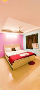 um quarto com uma cama grande num quarto cor-de-rosa em Goroomgo Chandrabindu Near Sea Beach Puri em Puri