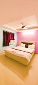 um quarto com uma cama grande e paredes roxas em Goroomgo Chandrabindu Near Sea Beach Puri em Puri