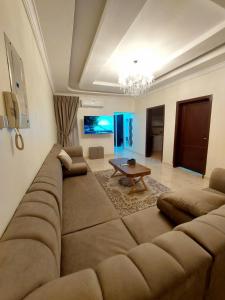 a living room with a large couch and a table at شقة واسعة غرفتين نوم وصالة in Tabuk
