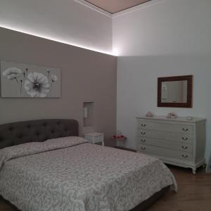 1 dormitorio con cama, tocador y espejo en Simarty Home en Marsala