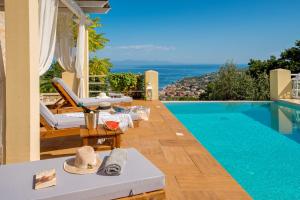 a villa with a swimming pool with a view of the ocean at Red Rose Artistsvillas in Gaios
