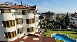 an apartment building with a view of a swimming pool at Семеен хотел"Свети Георги" in Burgas City