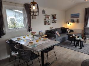 - un salon avec une table et un canapé dans l'établissement GEZELLIGE ZEEMEEUW Bed by the Sea, à Biggekerke