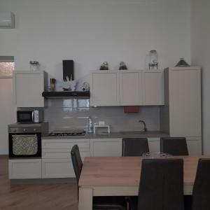 cocina con armarios blancos y mesa de madera en Simarty Home en Marsala