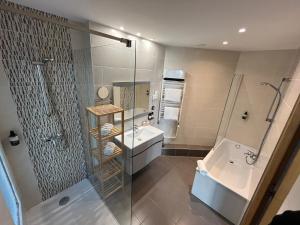 uma casa de banho com um chuveiro e um lavatório. em Le Prose Hôtel em La Grande-Motte