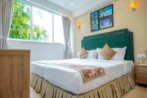 a bedroom with a large bed with a large window at Hotel Flora Inn Male Maldives in Male City