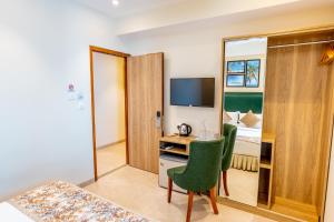 Hotel Flora Inn Male Maldives في مدينة ماليه: غرفة في الفندق مع مكتب وغرفة نوم
