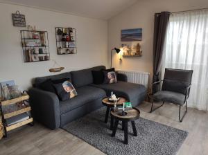 - un salon doté d'un canapé et d'oreillers pour 2 personnes dans l'établissement GEZELLIGE ZEEMEEUW Bed by the Sea, à Biggekerke