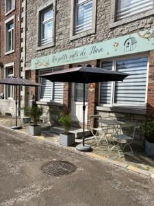 une table et un parasol devant un bâtiment dans l'établissement Les petits nids de Nina 1, à Fosses-La-Ville