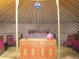 a room with a bed in a yurt with chairs at Le Mas Nomade in Callian