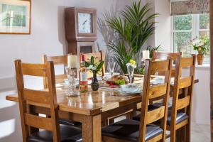 mesa de comedor con sillas, mesa de madera y sillas en Landlords Cottage a Country Retreat, en Wellington