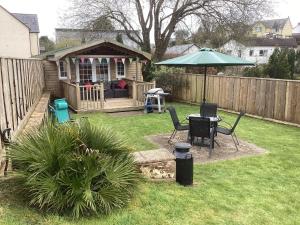 un patio trasero con una mesa y una sombrilla en Landlords Cottage a Country Retreat, en Wellington