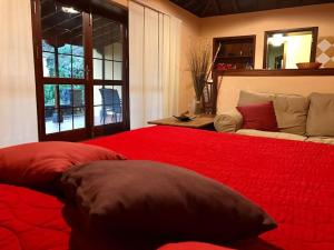 um quarto com uma grande cama vermelha e um sofá em RUSTIC HOUSE LA MONTAÑA em Breña Baja