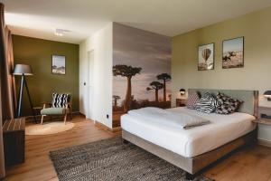 a bedroom with a large bed with a painting on the wall at Sunderland Hotel in Sundern