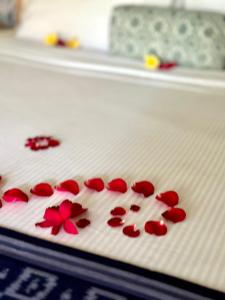 a white cutting board with red flowers on it at Umah Arya Homestay in Gianyar