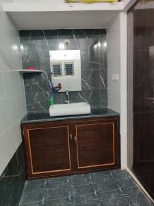 uma casa de banho com um lavatório e um micro-ondas em The Home Mars call 8O882-37972 em Mysore