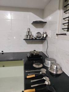 uma cozinha com fogão com panelas e frigideiras em The Home Mars call 8O882-37972 em Mysore