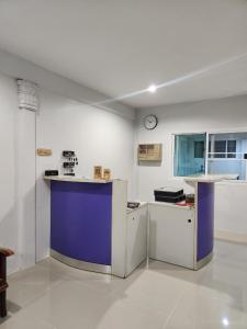 a white and purple kitchen with a clock on the wall at No.9 Hostel kanchanaburi in Ban Don Rak