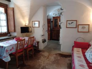 a dining room with a table and chairs and a tv at Baita del Plan in Pragelato